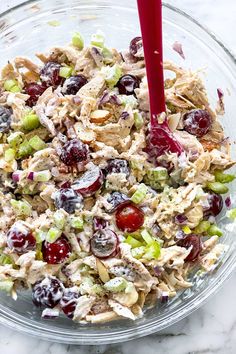 a glass bowl filled with chicken salad and grapes