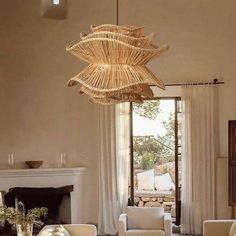 a living room filled with furniture and a chandelier hanging over the fire place