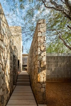 an outdoor walkway with stone walls and steps leading up to the building's entrance