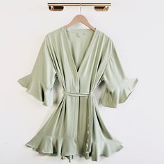 a green robe hanging on a white wall