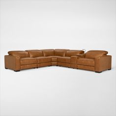 a brown leather sectional sofa sitting on top of a white floor