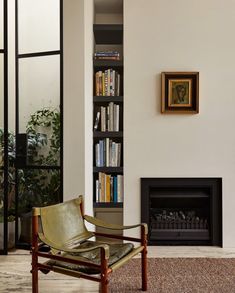 a chair sitting in front of a book shelf with books on it's shelves