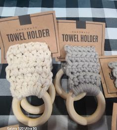 three crocheted objects are sitting on a plaid tablecloth with two wooden rings