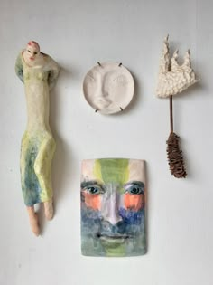 three ceramic figurines, one with a man's face and another with a woman's head