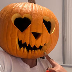 a person is carving a jack o lantern into their face with a toothpick