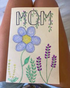 a child's drawing of a flower with the word mom written on it in front of her stomach