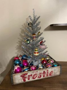 a wooden crate filled with christmas ornaments on top of a table