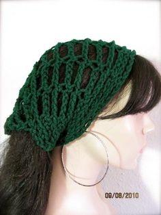 a woman wearing a green knitted headband on top of a mannequin