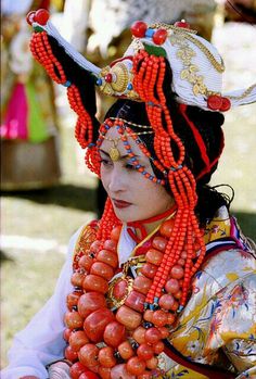 a woman wearing an elaborate headdress and beads