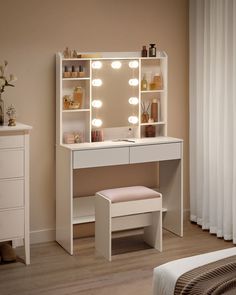 a white dressing table with lights on it