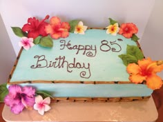 a birthday cake decorated with flowers and leaves