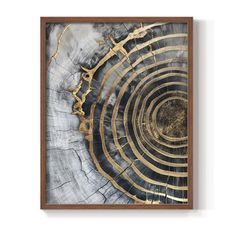 an abstract art piece with gold and black paint on it, framed in a wooden frame