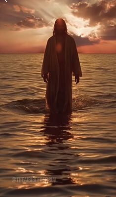 a person standing in the water at sunset