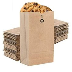 a brown paper bag filled with cookies on top of stacks of papers