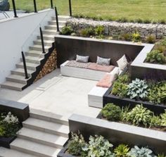 an outdoor seating area with stairs and plants