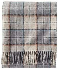 a plaid blanket with fringes on the bottom and one in grey, orange and white