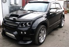 a black suv parked in front of a building