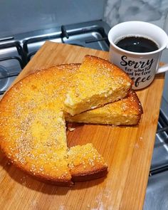 a cake on a cutting board next to a cup of coffee