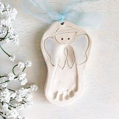 a ceramic ornament with an angel on it next to some baby's breath flowers