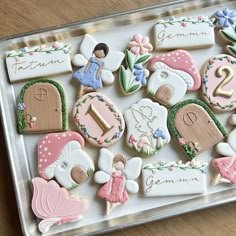 decorated cookies in the shape of houses and fairy doors on a tray with name tags