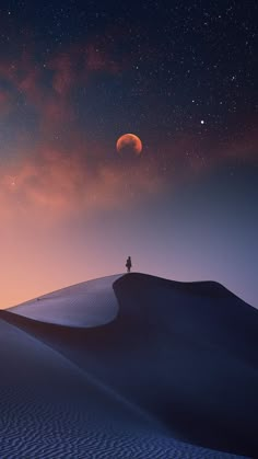 a person standing on top of a sand dune under a night sky filled with stars