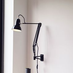 a black lamp mounted on the wall next to a window