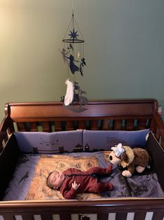 a baby laying in a crib with stuffed animals