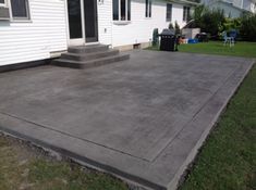 a concrete patio in front of a white house