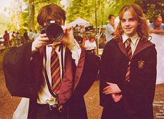 two young people dressed in harry potter outfits, one holding a camera and the other taking pictures