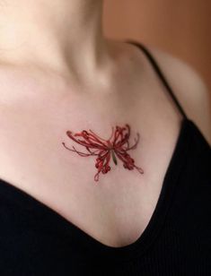 a woman's chest with a red flower tattoo on her left shoulder and right breast