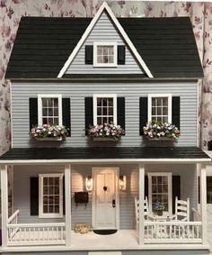 a doll house with flowers in the window boxes on the front and side of it