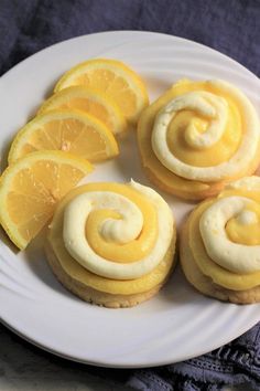 lemon cookies with icing and orange slices on a white plate