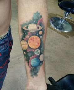 a man with a tattoo on his arm and leg that has planets all over it