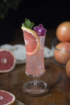 a grapefruit cocktail garnished with fresh flowers