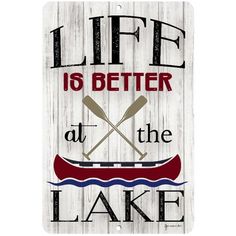 a sign that says life is better at the lake with two canoes on it