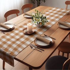 a table set with place settings and flowers on the top, next to a window