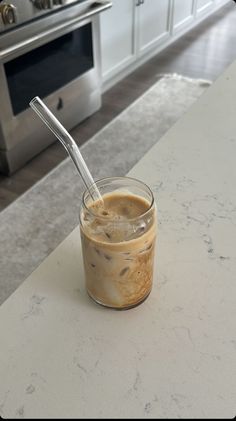 a glass jar filled with liquid sitting on top of a counter next to an oven