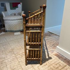 a wooden chair sitting on top of a carpeted floor next to a white couch