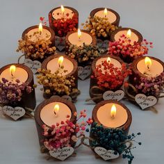 a bunch of candles that are sitting in the middle of a table with flowers on them