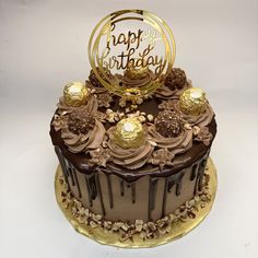 a birthday cake with chocolate frosting and gold decorations