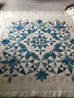 a blue and white quilt is laying on the floor