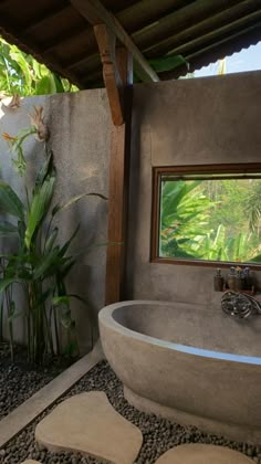 a bathroom with a stone bathtub next to a bamboo tree