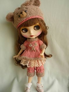 the doll is wearing a bear hat and dress