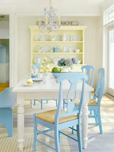 a dining room table with blue chairs and plates on it