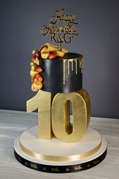 a black and gold birthday cake with the number 10 on it's top tier