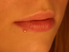 a woman's lips with a tiny diamond on the tip of her lip and nose