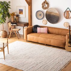 a living room filled with lots of furniture and decor on the wall above it is a brown leather couch