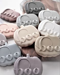 several decorated cookies in the shape of pumpkins with letters on them, sitting next to each other