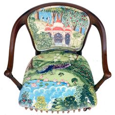 an upholstered chair with a painting on it's back and armrests