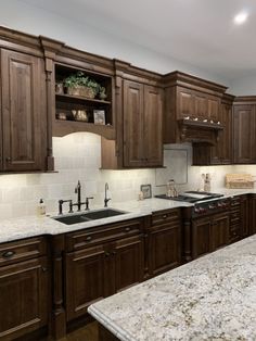 a kitchen with wooden cabinets and marble counter tops